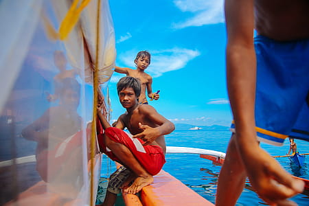 Teenage Boys Sitting on Edge of Boat thumbnail