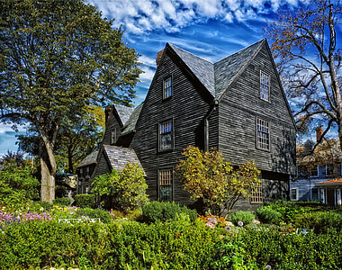 gray wooden 3-storey house surrounded of trees and flowers thumbnail