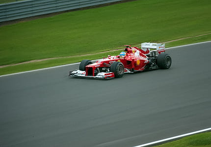 red Ferrari F1 on concrete road during daytime thumbnail