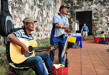 man playing acoustic guitar beside standing man at daytime thumbnail