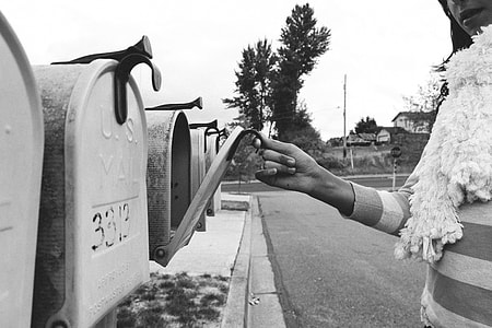 grayscale photo of a woman opened the mailbox thumbnail