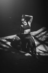 grayscale photography of woman sitting on vehicle tire thumbnail