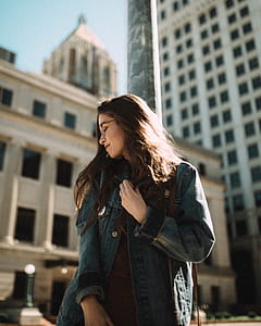selective focus photography of woman looking right while leaning on post thumbnail