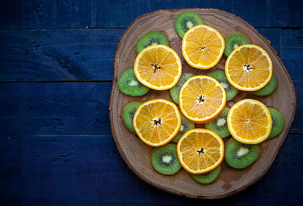 citrus fruit and kiwi on brown slab thumbnail