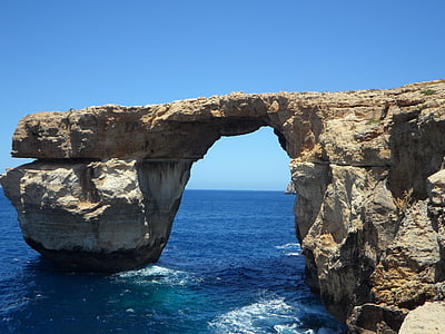 grey arc sea rock formation during clear blue sky thumbnail
