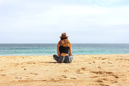 Woman Sitting on Seashore at Daytime thumbnail