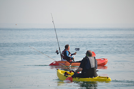 two men riding orange and yellow canoes thumbnail