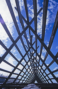 low angle photo gray metal bridge under blue sky thumbnail