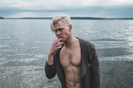 photo of man wearing black coat with sea background thumbnail