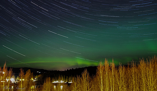 time lapse photography of grass field under northern lights thumbnail