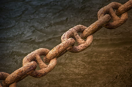 rusted brown chains near body of water thumbnail