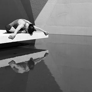 grayscale photo of woman sitting near body of water thumbnail