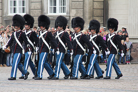 man wearing black-and-blue uniform marching on street at daytime thumbnail