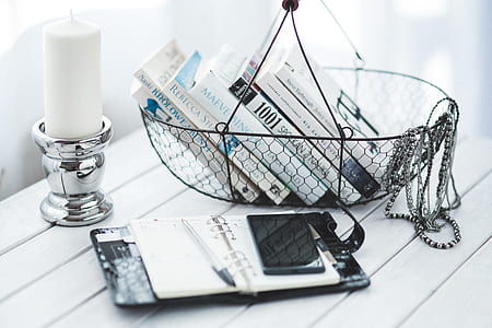 black steel basket and white pillar candle on stainless steel candle holder thumbnail