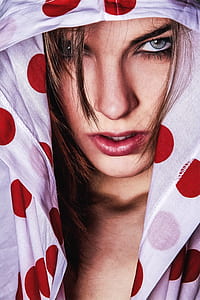 woman hiding in white polka-dot hoodie photography thumbnail