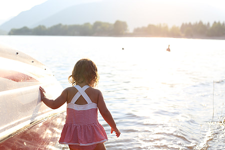 girl standing on water beside white boat thumbnail