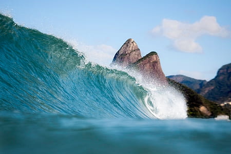 water wave beside gray rock formation thumbnail
