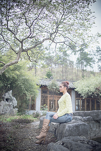 woman sitting on rock outdoors thumbnail