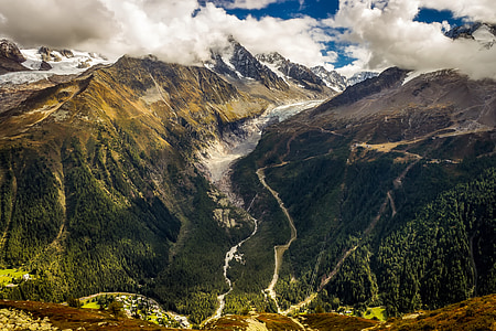 aerial photography of road on side of two mountains under white cloudy skies at daytime thumbnail
