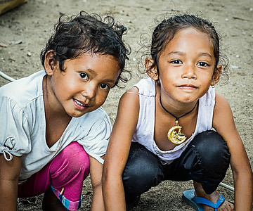 two kids squatting on beige dirt during daytime thumbnail