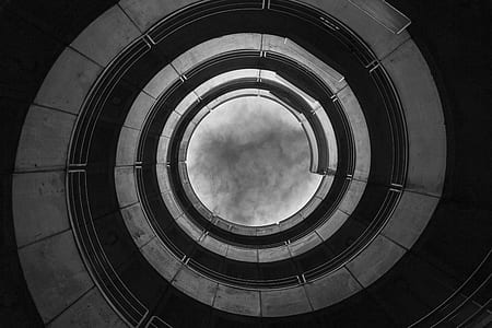 worms-eye view photography of spiral staircase in grayscale thumbnail