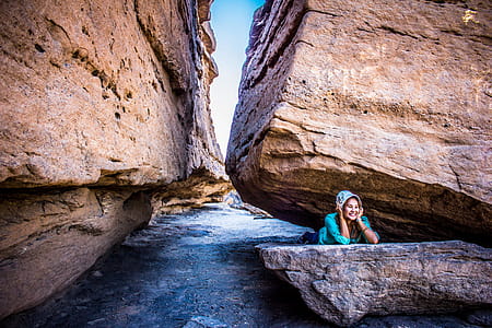 Woman Lying Between Rock Formation at Daytime thumbnail