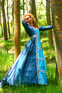 woman wearing blue long-sleeved gown standing near tree thumbnail