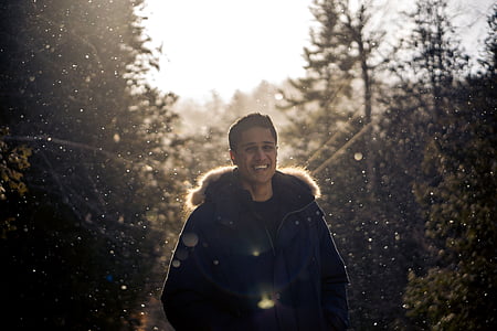 man standing beside green trees thumbnail