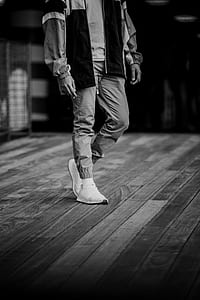 grayscale photography of person standing on plank floor thumbnail