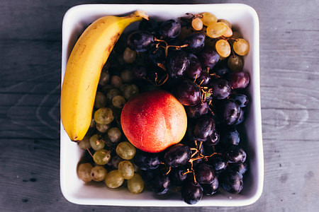 Overhead shot of a bowl of fruit on a wooden table thumbnail