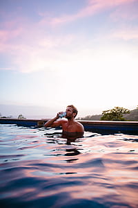 man in swimming pool drikning from tin can thumbnail