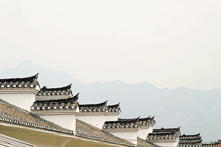 white concrete building near mountain during daytime thumbnail