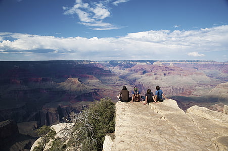 four men sitting on top of hill thumbnail