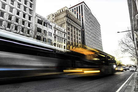 vehicle passing on road near building in time lapse photography thumbnail