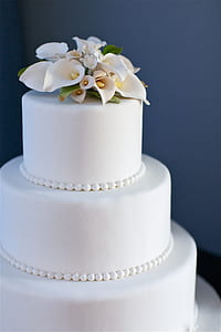 white icing coated 3-tier fondant cake photograph thumbnail