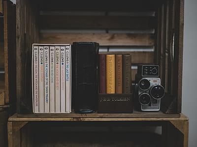 camera beside assorted-title books thumbnail