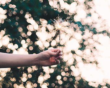 selective focus photography of person holding sparkler firework thumbnail