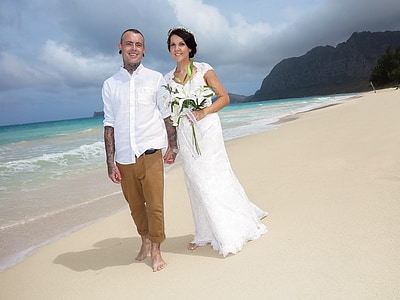 bride and groom standing near ocean water during daytime thumbnail
