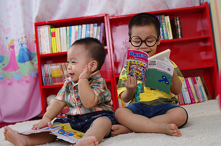 two boys reading books while sitting on floor thumbnail