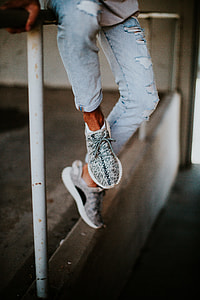 person wearing blue distressed jeans and pair of Zebra Adidas Yeezy Boost 350 thumbnail