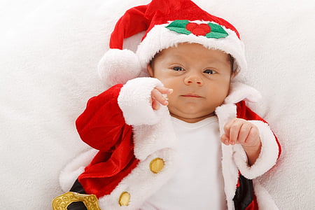 baby laying on white bed sheet thumbnail