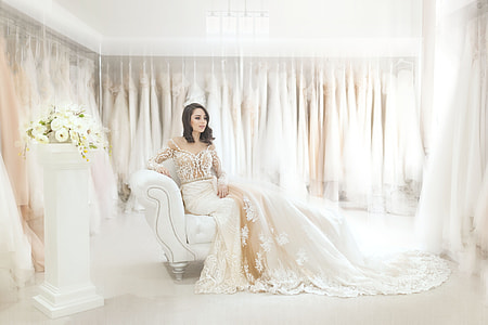 woman in white wedding dress seating on couch thumbnail