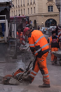 man using concrete saw in street during daytime thumbnail