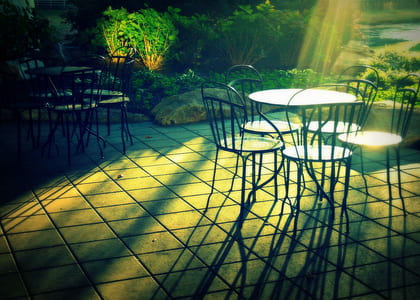 patio tables and chairs on gray concrete pavement thumbnail