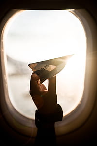 person holding paper plane inside plane thumbnail