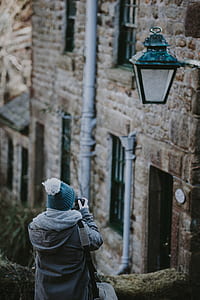 person taking picture of concrete building thumbnail