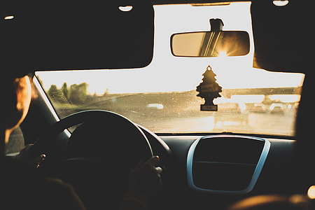 person sitting on driver's seat inside vehicle during golden hour thumbnail