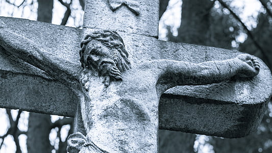 gray concrete crucifix near trees by day thumbnail