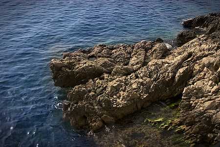 brown rock formation near body of water thumbnail