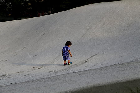 boy playing on gray sand field thumbnail